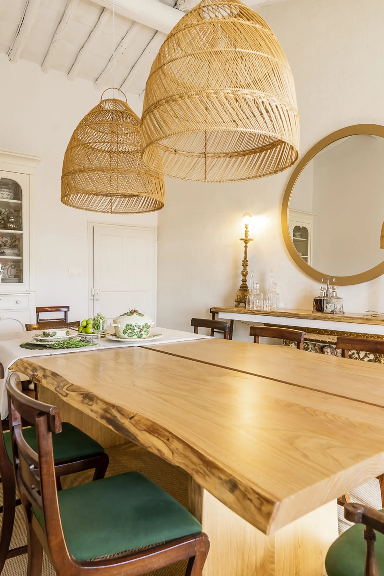 A sala de jantar vista de conjunto, com o armário caiado ao fundo e o pavimento em fibra natural.